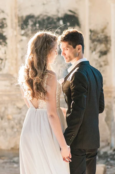 Bride and groom at wedding ceremony by the old cathedral — Stock Photo, Image