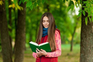 Romantik kız çimlere oturup kitap okumak
