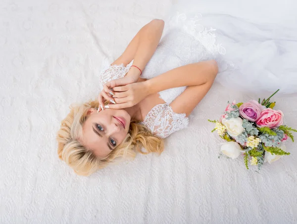 Beauty bride in wedding dress posing with bouquet in hands