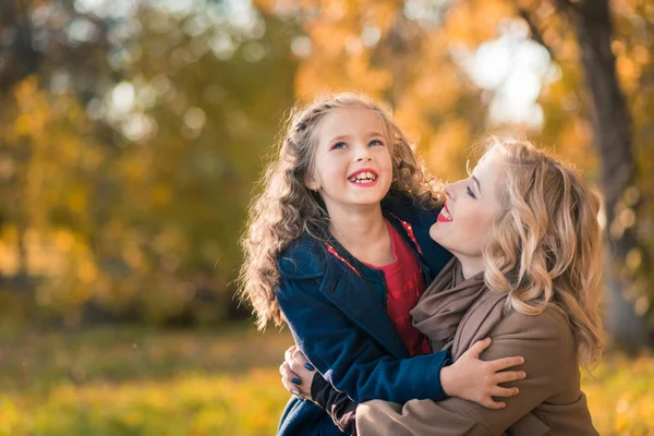 Happy joyful woman having fun with her girl in autumn color — Stock Photo, Image