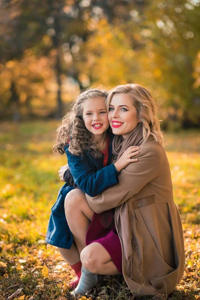 Feliz mulher alegre se divertindo com sua menina na cor do outono — Fotografia de Stock