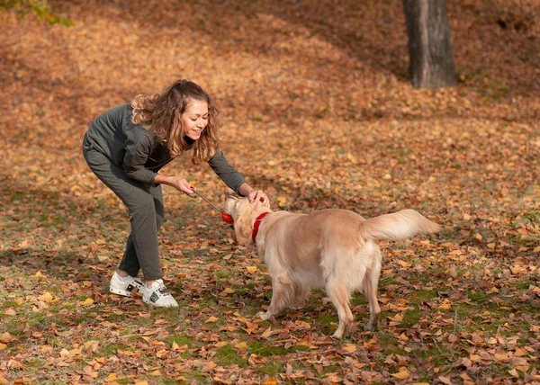 Jeune femme jouant avec son chien au parc — Photo