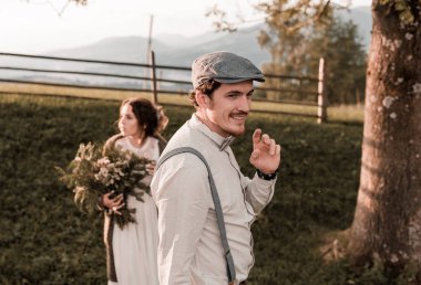 Düğün çift, damat ve gelin bir arka plan dağ üzerinde düğün kemer yakınında