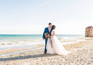 Gelin ve damat düğün töreninde deniz kenarında