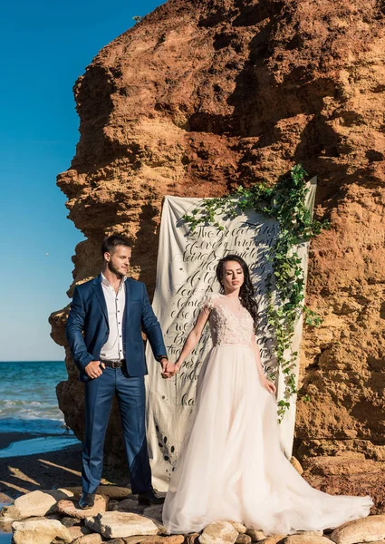 Couple de mariage, marié et mariée en robe de mariée près de la mer à la mer — Photo