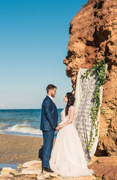 शादी की जोड़ी, दुल्हन और दुल्हन समुद्र के किनारे समुद्र के पास शादी की पोशाक में — स्टॉक फ़ोटो, इमेज