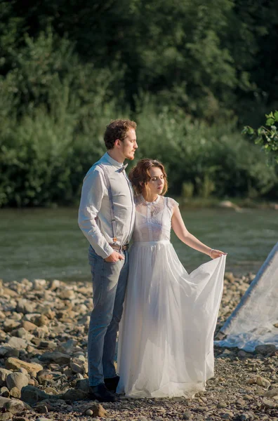 美しい風景の上に山の岩のヴィンテージスタイルの服を着て新婚夫婦 — ストック写真