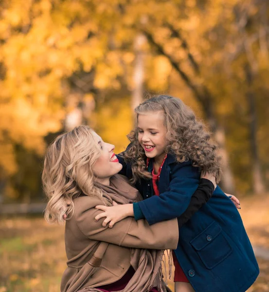 Beautiful mother and daughter in colorful autumn outdoors — Stock Photo, Image