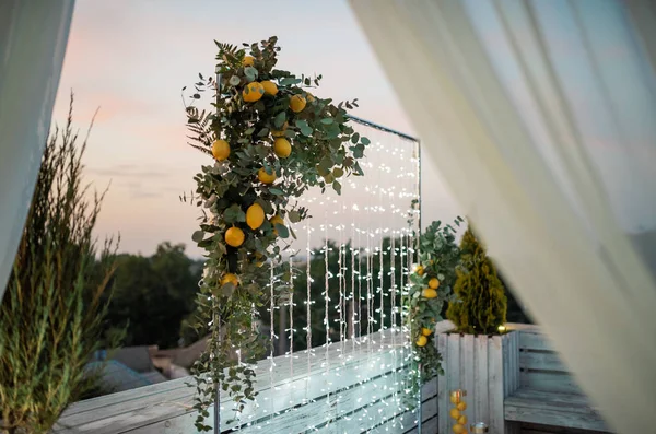 bright wedding arch of fruits, and lemons outdoors.