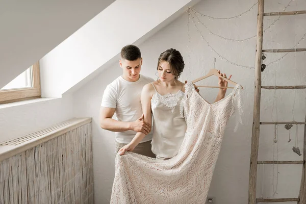 Sposa bruna sorridente in un cappotto bianco e lingerie. La mattina della sposa . — Foto Stock