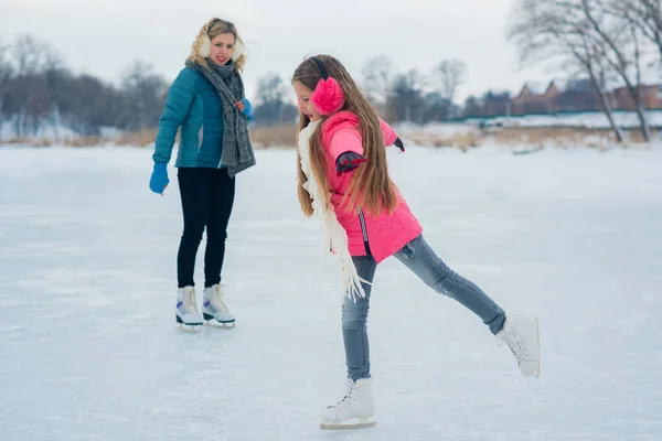 Young family have fun on the ice area in a snowy park — Stock Photo, Image