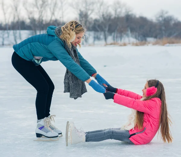 Ung familj ha kul på is området i en snöig park — Stockfoto