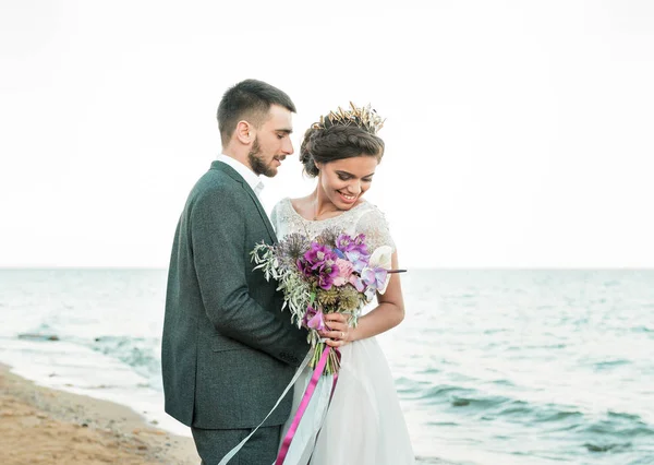 Pareja de boda, novio y novia en vestido de novia cerca del mar en la playa — Foto de Stock