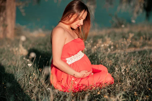迷人的怀孕妇女带着鲜花在外面的海滩上 怀孕女孩肖像 健康怀孕 — 图库照片