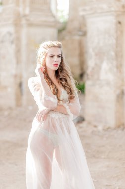 Dalgalı kıvırcık saçlı beyaz dantelli bir gelinin portresi.