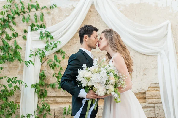 Bride and groom at wedding ceremony by the old cathedral — Stock Photo, Image