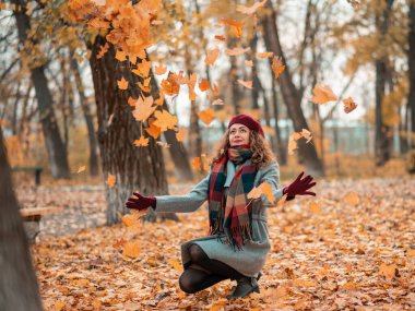 Sonbahar arka planında doğal, şirin saçlı, renkli yapraklı, rüya gibi güzel bir kız..