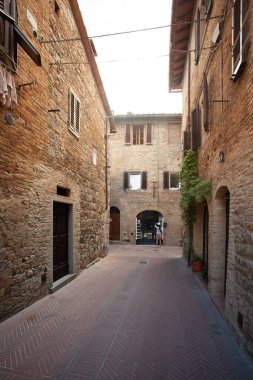 San Gimignano, İtalya - 12 / 09 / 2013: Ortaçağ San Gimignano Toskana Caddesi 'nin ılık renkleri