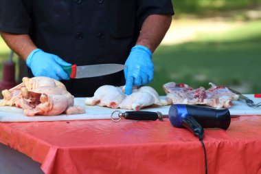 aşçı baharatlarla tembellik için bir tavuk temizler.