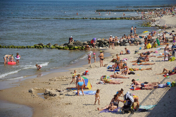 Туристы и местные жители отдыхают на пляже.