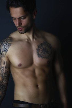 Dövmeli adam gri arka plan üzerinde kusursuz bir beden ile 