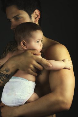 Yakışıklı babası onun genç bebek kız siyah bir arka plan üzerinde tutan 
