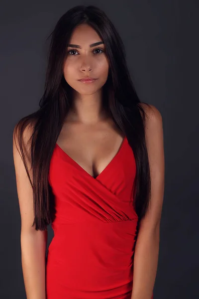 Gri Üzerine Kırmızı Bir Elbise Giyen Güzel Genç Kadın — Stok fotoğraf