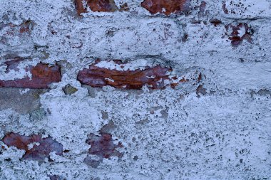 Kısmen beyaz alçılı, arka planda eski bir tuğla duvar dokusu