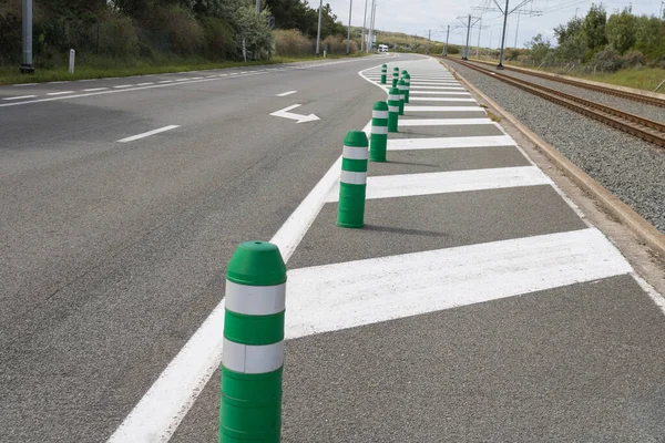 Trafiği dolaştırmak için uzun sıra yeşil bariyer varilleri. Yol bakımı, inşaat tabelası altında.