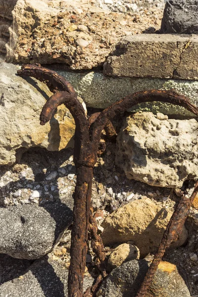 Velha âncora enferrujada em um fundo de pedras — Fotografia de Stock