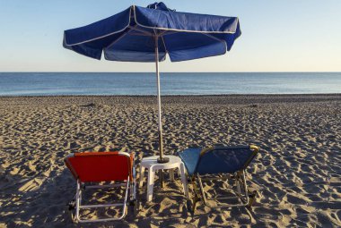deniz kıyısında bir şemsiye ve şezlong yatay görünümü