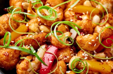 Geçmişi karanlık Kung Pao Karnabahar. Sichuan Kung Pao Karnabahar acı biber, fıstık, sos ve soğanlı Çin mutfağı vejetaryen yemeğidir. Kapat.