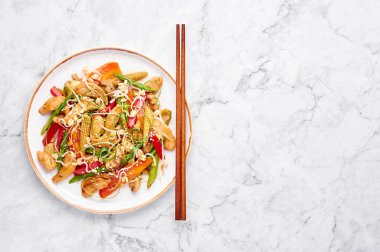 Tavuk Budu Suey beyaz tabakta mermer arka planda. Chop Suey, farklı kızarmış sebzeler, tavuk eti ve soslarla karıştırılmış Amerikan Çin mutfağı. Uzayı kopyala Üst Manzara. Amerikan yemekleri..