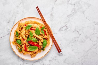 Tayland Sarhoş Eriştesi ya da beyaz mermer arka planda Pad Kee Mao. Sarhoş Erişte, Tayland mutfağında pilav, erişte, tavuk eti, fesleğen, sos ve sebze. Tayland yemeği. Uzayı kopyala Üst görünüm