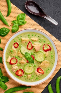 Tay yeşili körili tavuk ya da beyaz kasede siyah arka planda Gaeng Kaew Wan Gai. Tayland yeşil köri yeşil biber, fesleğen, hindistan cevizi sütü, sebze ve baharatlı Tayland mutfağıdır.