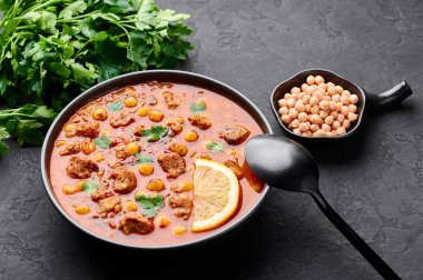 Fas Harira Çorbası, siyah kâse içinde. Harira, kuzu eti, et, nohut, mercimek, domates ve ciliantro ile birlikte Fas mutfağından. Ramazan İftarı. Boşluğu kopyala