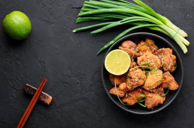 Karaage usulü tavuk, siyah kasede, arka planda. Karaage, bol yağda kızartılmış tavuklu geleneksel Japon mutfağı. Uzayı kopyala Üst görünüm