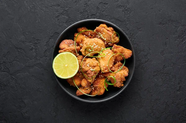 Karaage usulü tavuk, siyah kasede, arka planda. Karaage, bol yağda kızartılmış tavuklu geleneksel Japon mutfağı. Uzayı kopyala Üst görünüm