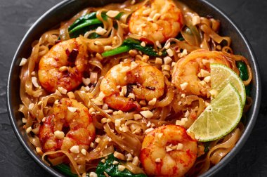 Karides altlığı. Siyah kasede, arka planda Ew. Pad See Ew, Tayland mutfağında pilav, erişte, karides, soya ve istiridye sosu ve yeşillik. Tayland yemeği. Kapat.