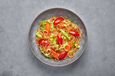 Sebze Pad Woon Sen ya da Tayland Bardağı Erişte Karıştırma veya gri beton arka planda Pad Thai. Vejetaryen Pad Woon Sen, Tayland 'da bulunan bir erişte, domates, havuç, yumurta ve sostur. Tayland Yemeği.