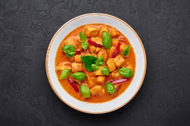 Beyaz tabakta, arka planda Tayland Panang Tavuk Köri 'si. Phanaeng Curry, Tayland mutfağı. İçinde tavuk, kaffir limon yaprağı, kırmızı köri sosu ve sebze var. Tayland yemeği. Tayland yemeği.