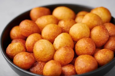 Loukoumades veya Luqaimat veya siyah kasede lokma. Loukoumades, Ramazan 'da popüler olan bir doğu mutfağı çöreğidir. Popüler Ramazan Yemeği. İftar ve Suhur tatlıları. Kapat.