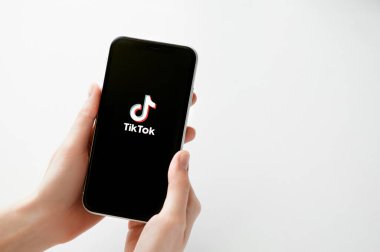 Moskova, Rusya, 28 Nisan 2020. Siyah ekranda Tik tok uygulama logosu beyaz fon üzerinde İphone X. Tiktok sosyal medya ağı. Tik tok uygulama simgesi akıllı telefon ekranında. Kadın elinin telefonu var.