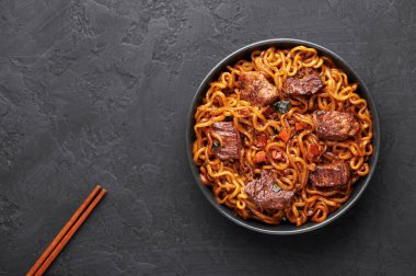 Ram-Don ya da Chapaguri eriştesi ve siyah kasede biftek. Jjapaguri, erişte, udon eriştesi ve biftekli popüler bir Güney Kore yemeğidir. Boşluğu Kopyala