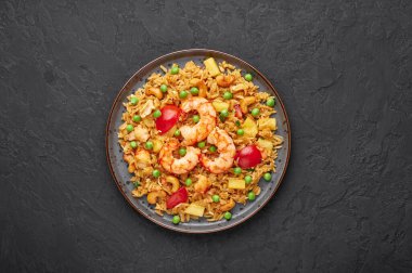 Tayland Pineapple Fried Rice ya da Kao Pad Sapparod siyah bir tabakta, arka planda. Kao Pad Sapparod bir Tayland mutfağı tabağıdır. Tayland yemeği. Asya yemekleri. Uzayı kopyala Üst görünüm
