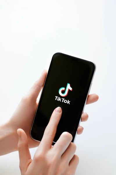Moskova, Rusya, 28 Nisan 2020. Siyah ekranda Tik tok uygulama logosu beyaz fon üzerinde İphone X. Tiktok sosyal medya ağı. Tik tok uygulama simgesi akıllı telefon ekranında. Kadın elinin telefonu var.