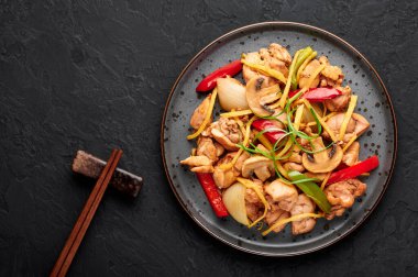 Tayland Ginger tavuğu ya da siyah arkaplanda siyah tabakta Gai Pad King. Gai Pad King, Tayland mutfağında tavuk eti, zencefil şeritleri, soğan, kapsiyum ve sosla servis edilir. Tayland yemeği. Boşluğu kopyala