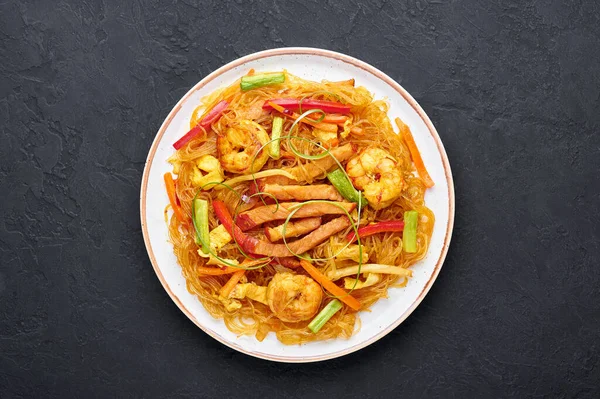 Singapur Mei Fun beyaz plakalı, siyah arkaplanlı. Singapur eriştesi, Çin mutfağında pilav, karides, char siu domuz eti, havuç, kırmızı soğan ve Napa lahanası ile servis edilir. Çin yemeği. Boşluğu kopyala