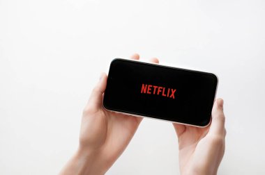 Moskova, Rusya, 28 Nisan 2020. Netflix uygulama logosu beyaz arkaplanda Iphone X ekranında. Akıllı telefon ekranında Netflix uygulama simgesi. Kadın elinin telefonu var.