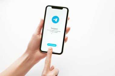 Moskova, Rusya, 28 Nisan 2020. Beyaz fon üzerinde Iphone X ekranında telgraf uygulama logosu. Akıllı telefon ekranında telgraf kurye uygulama simgesi. Kadın elinin telefonu var.